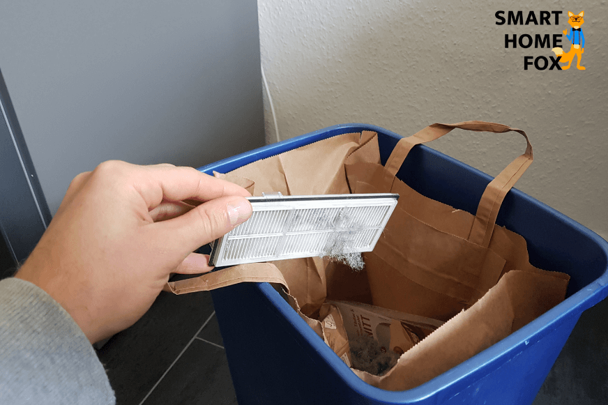 Der HEPA-Filter des Roborock S7 wird über einem Mülleimer ausgeklopft.